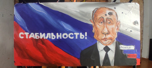 Billboard promoting "Stability" next to burning oil storage containers.