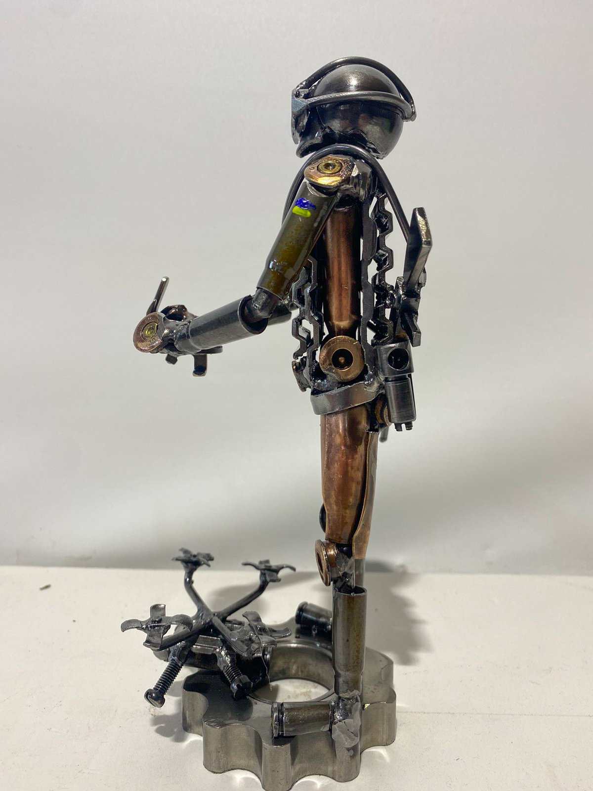 Sculpture of Ukrainian soldier operating FPV drone made from frontline shells