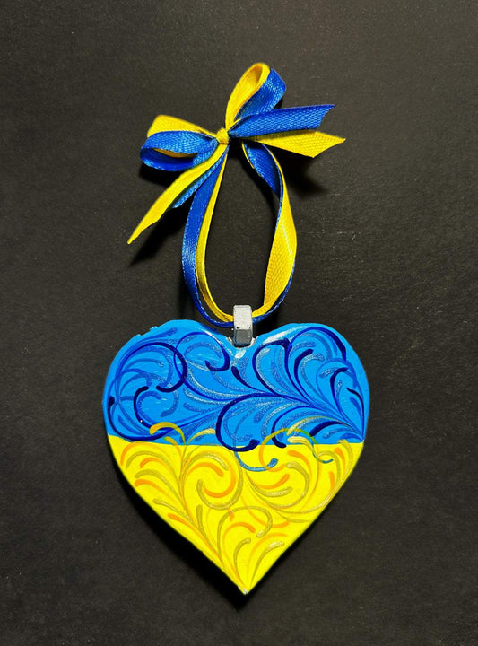 Iron Heart ornament made from 122mm grad rocket painted with Finnish and Ukrainian flags by Victory Gallery artist Anastasia Leonova