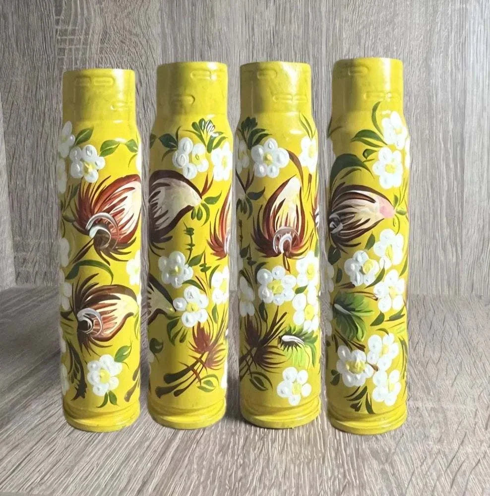 Ukrainian reward system featuring four yellow painted shell casings with white flowers, green leaves and brown motifs