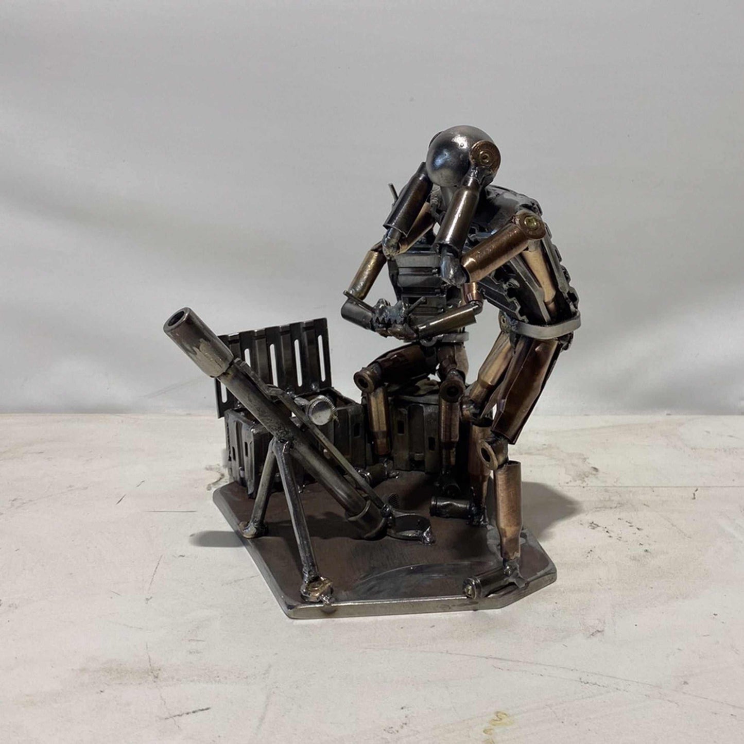 Sculpture of Ukrainian FPV drone operator and infantryman firing mortar made from frontline shells