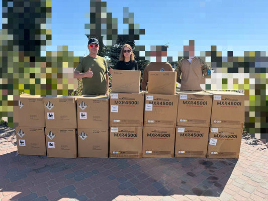 September 2026 Update newsletter showing three volunteers behind stacked brown MXR4500i generator boxes outdoors

