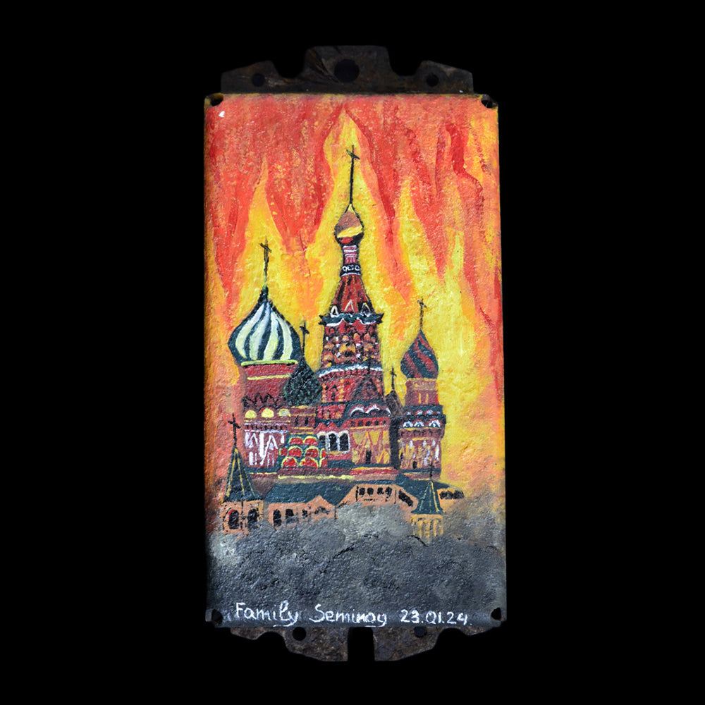 Burning Kremlin painted on turret piece of Ukrainian cabbage tank in garden