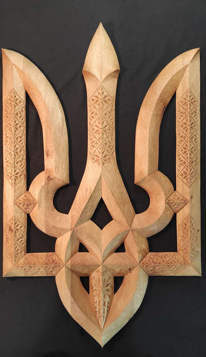 Hand carved wooden Tryzub sculpture by Vitalii Trokhymenko displayed on a stand
