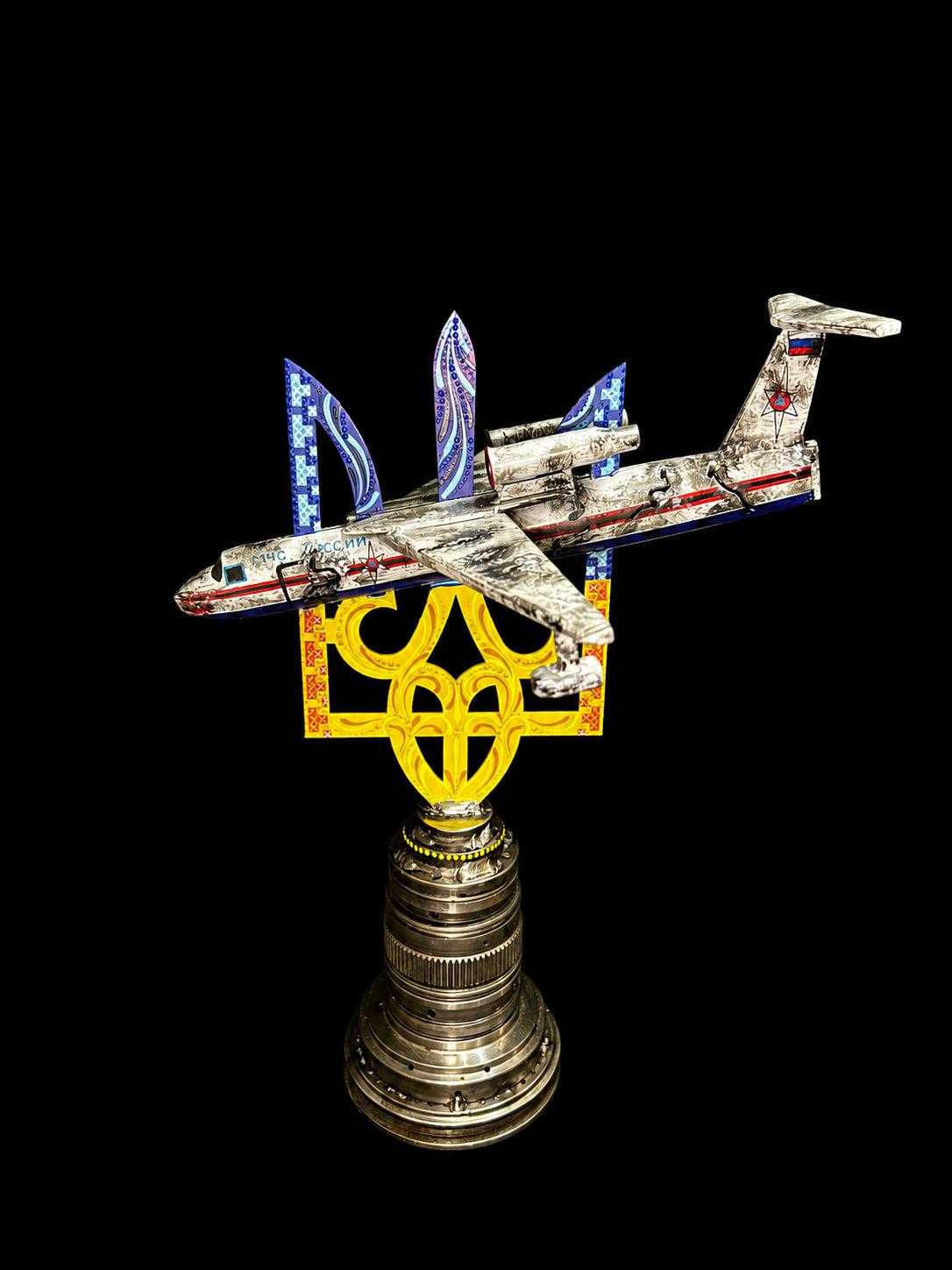 Beriev Be-200 model impaled on Tryzub sculpture