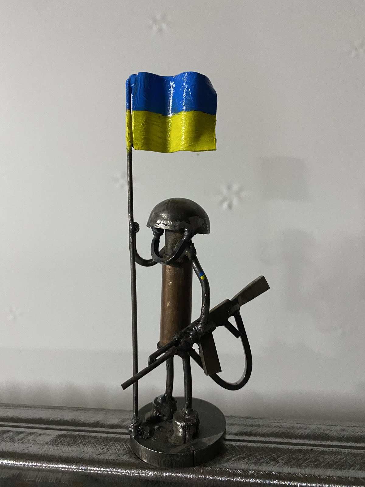 Mini-Soldier sculpture holding Ukrainian flag, 17cm tall, by Hisoshi Art Studio made from frontline shells