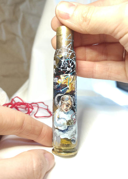 Mother waiting for missing son embroidered on small caliber shell with candle, phone, and photo.