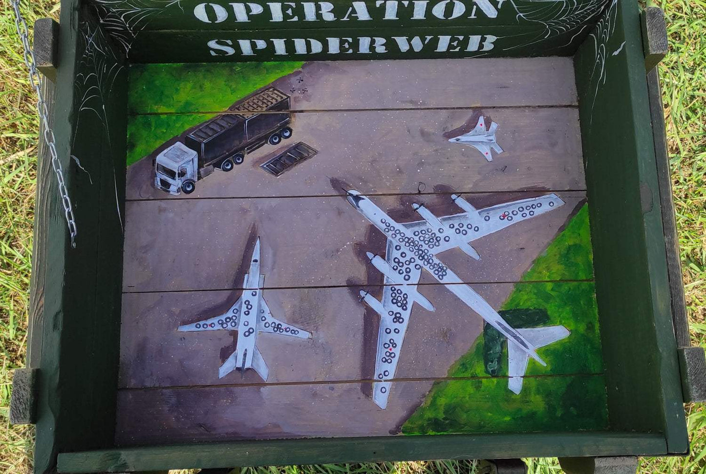 Operation Spiderweb painted ammunition box by Tanya Shacun with artistic war relief theme