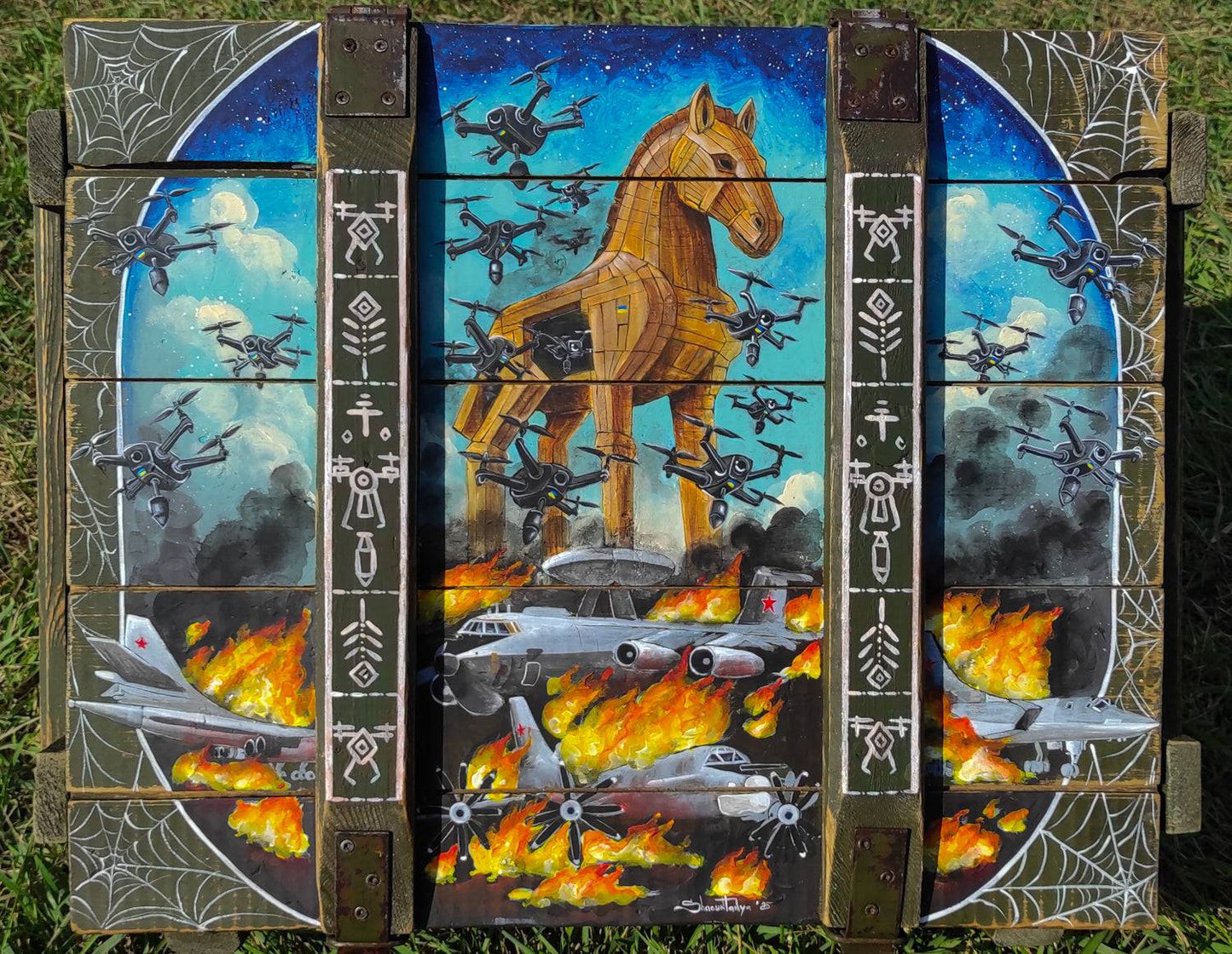 Operation Spiderweb painted ammunition box by Tanya Shacun with a cat nearby