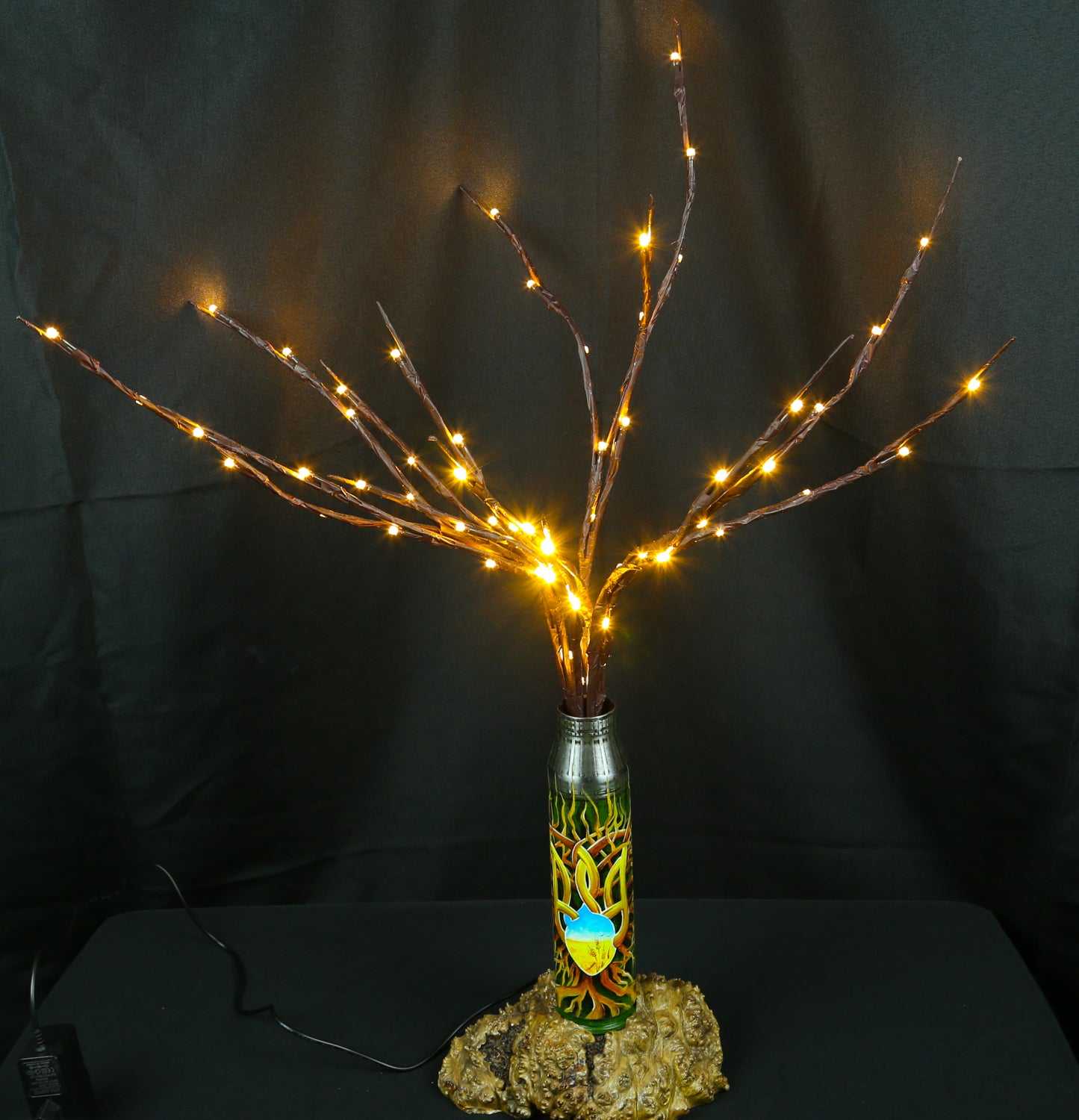 Tree of light sculpture growing from a spent Gepard shell near a European 220V outlet designed by Tanya Shacun