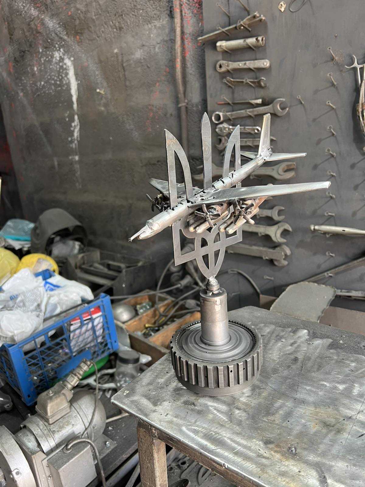 TU-95 aircraft sculpture impaled on Tryzub symbol by Hisoshi Art Studio