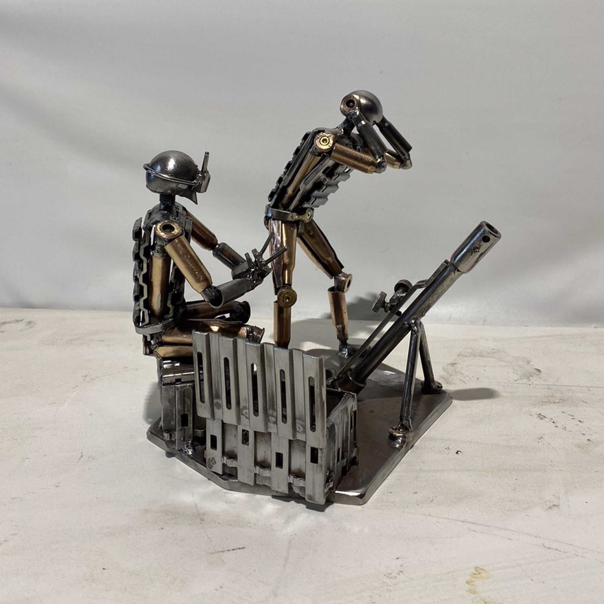 Sculpture of Ukrainian FPV drone operator and infantryman firing a mortar made from frontline shells