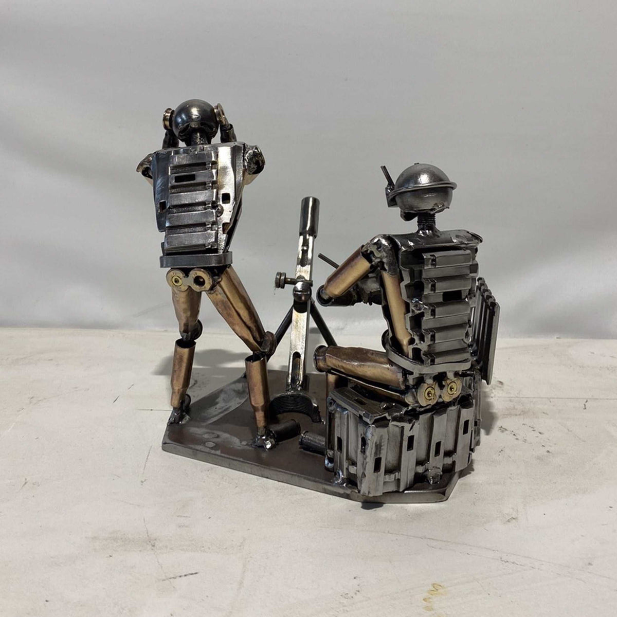 Sculpture of Ukrainian FPV drone operator and infantryman firing mortar made from frontline shells