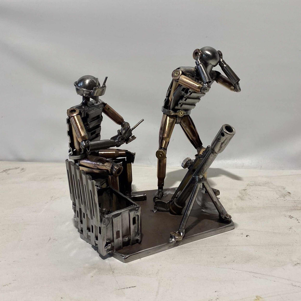 Sculpture of Ukrainian FPV drone operator and infantryman firing mortar made from frontline shells