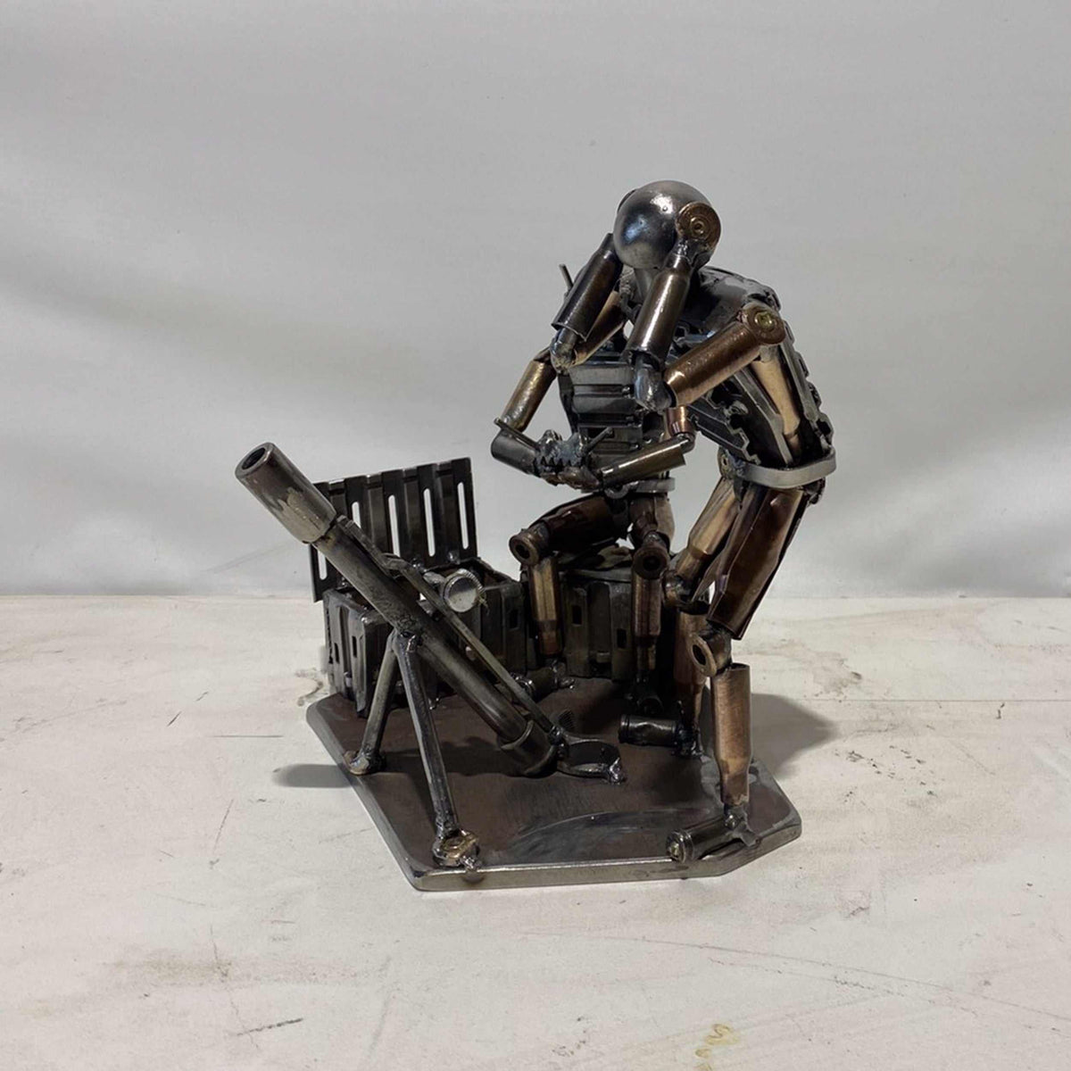 Sculpture of Ukrainian FPV drone operator and infantryman firing mortar made from frontline shells