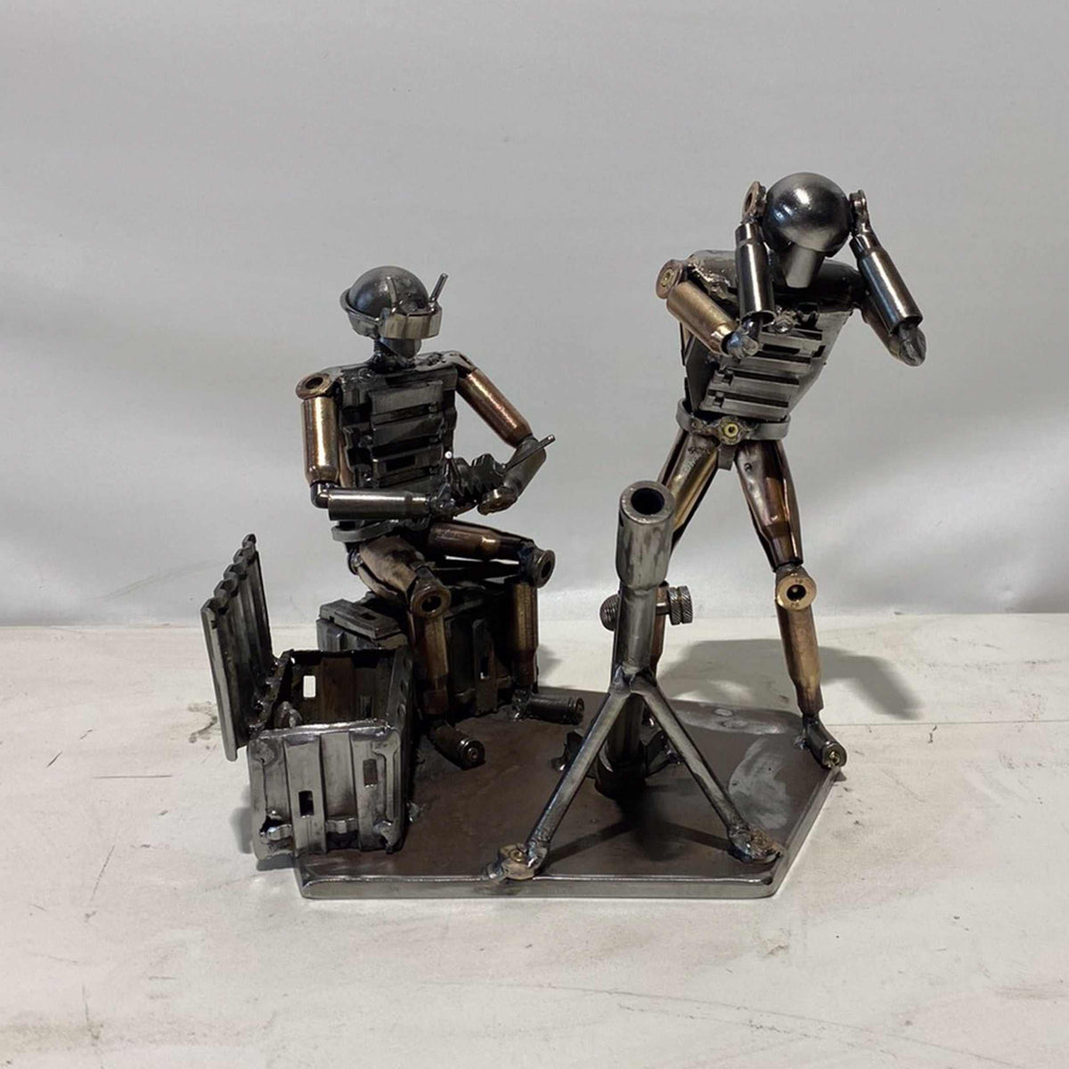 Sculpture of Ukrainian FPV drone operator and infantryman firing mortar made from frontline shells