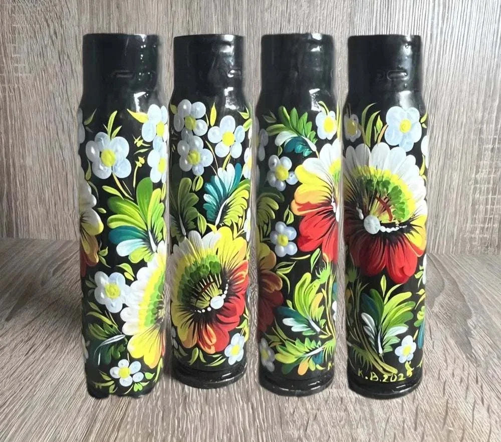 Ukrainian reward system featuring four black 30 mm shell casings hand-painted with colourful flowers and folk motifs