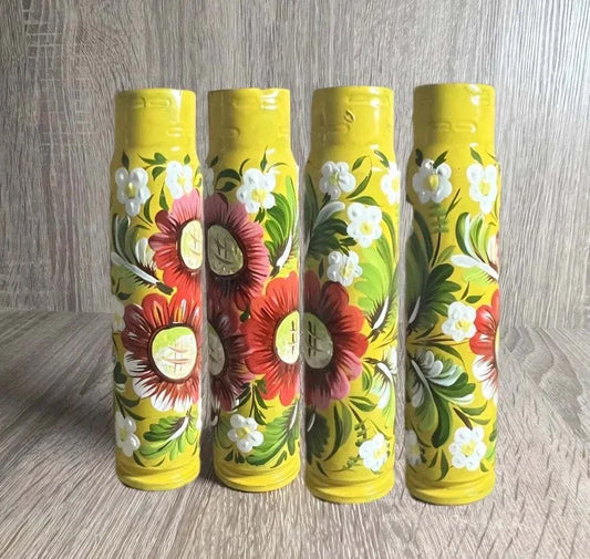 Ukrainian reward system featuring four yellow painted 30mm shell casings with red and white floral patterns