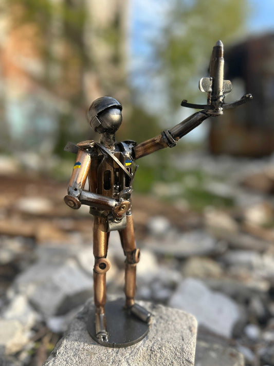 Sculpture of Ukrainian Soldier with flag launching drone interceptor made from frontline shells