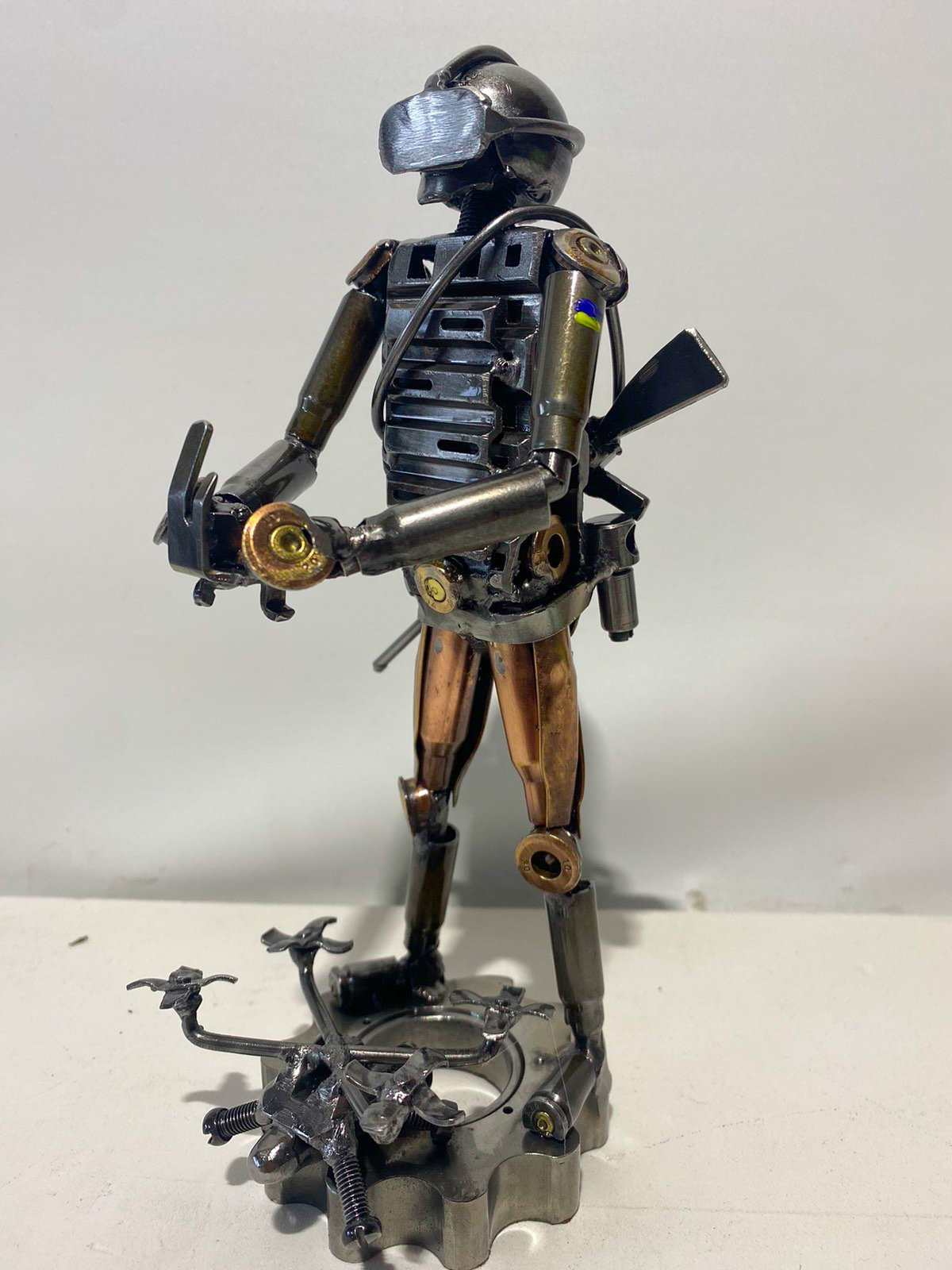 Sculpture of Ukrainian soldier operating FPV drone made from frontline shells