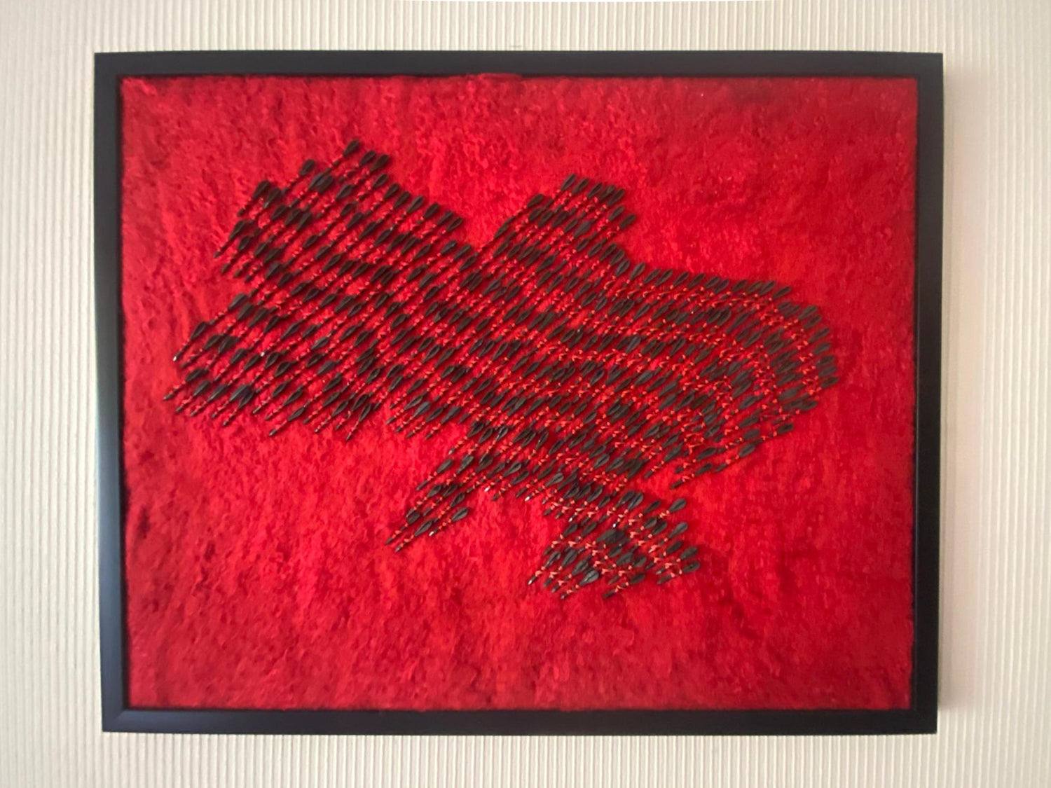 Wool map of Ukraine in red with 300 fletchettes symbolizing air raid sirens and missile attacks