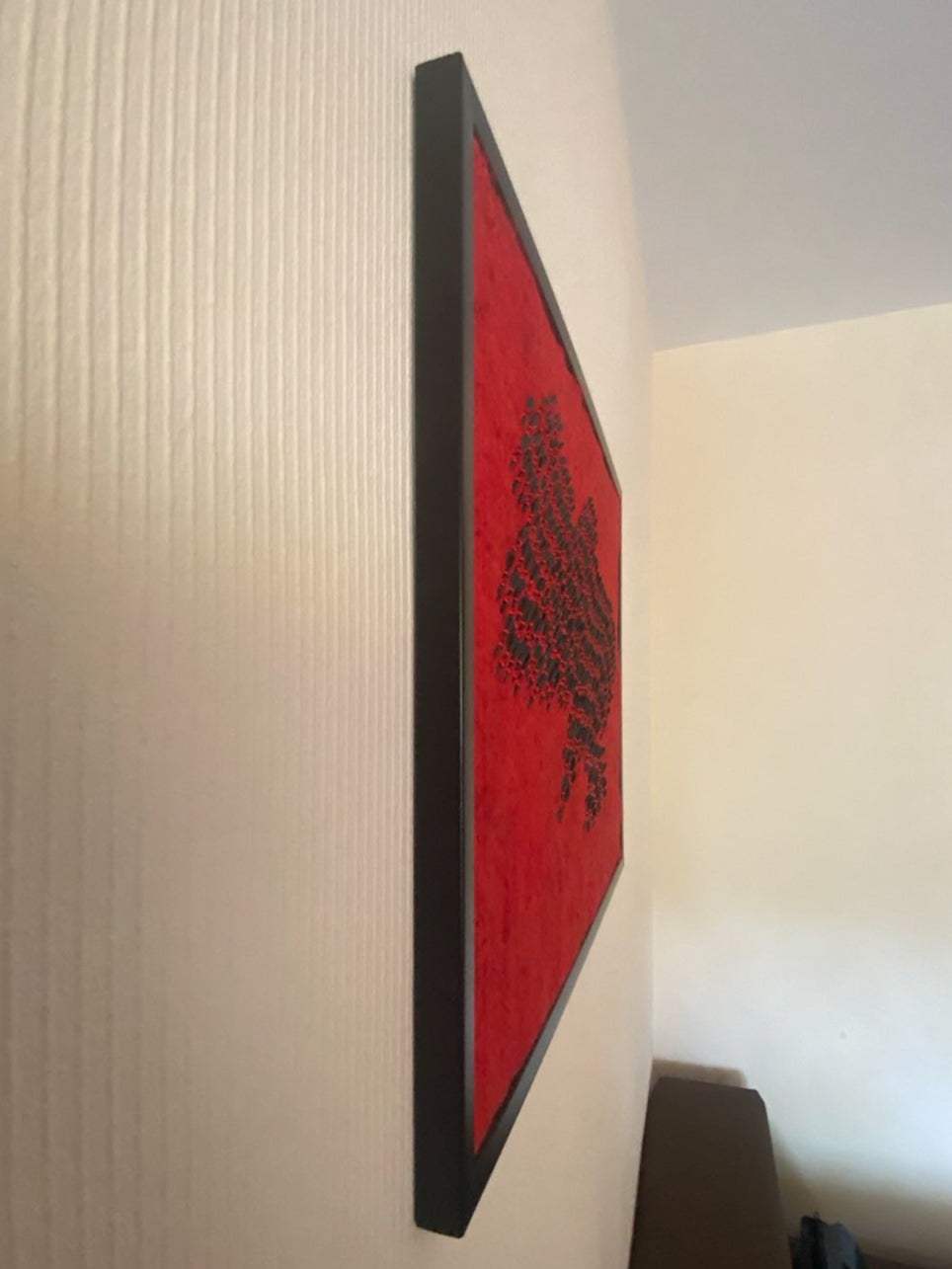 Wool map of Ukraine in red with fletchettes symbolizing missile strikes during air raid sirens